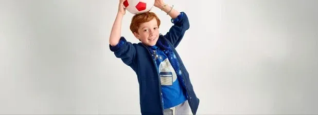 Boy wearing a blue sherpa fleece hoodie over a blue shirt.