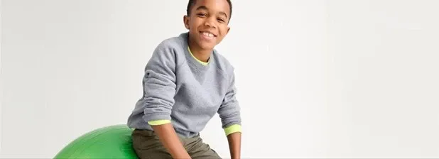 Boy wearing a gray crewneck sweater.