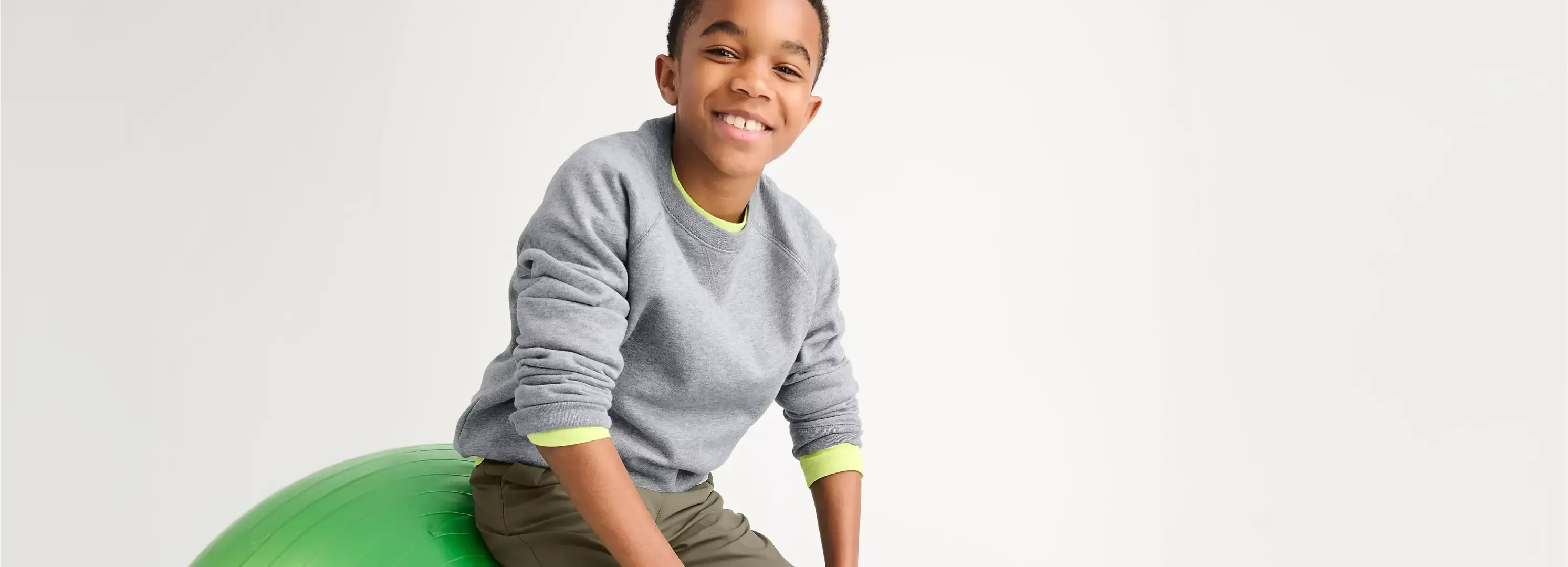 Boy wearing a grey crewneck sweater.