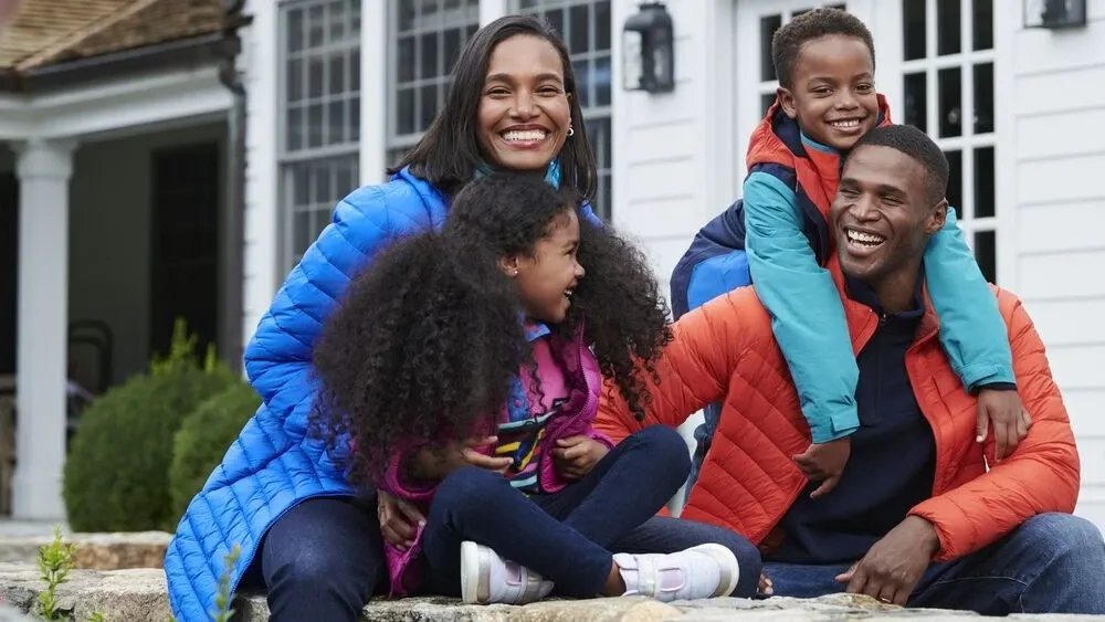 A family of four wearing Lands' End down puffer jackets.