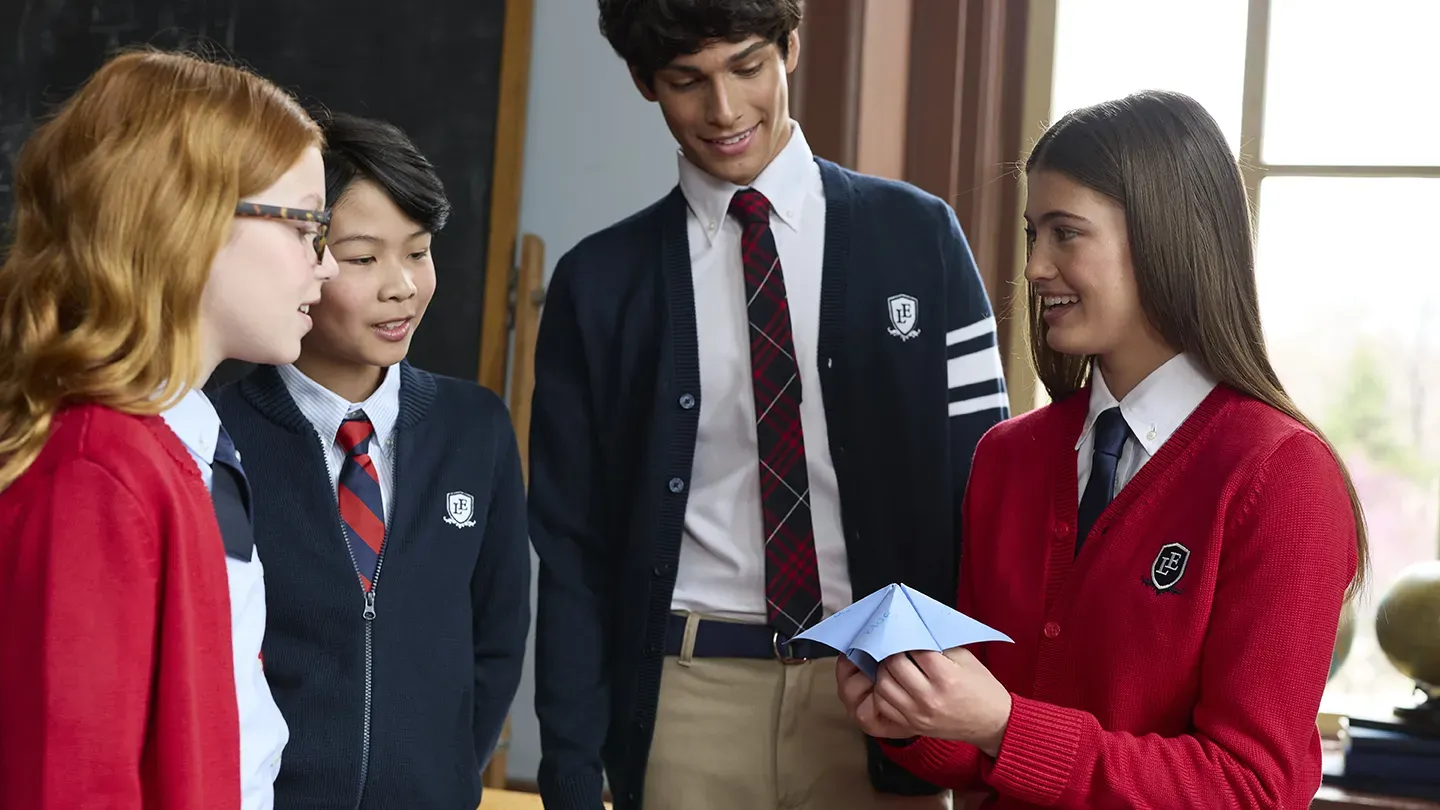 Four students in a classroom wearing Lands' End school uniforms