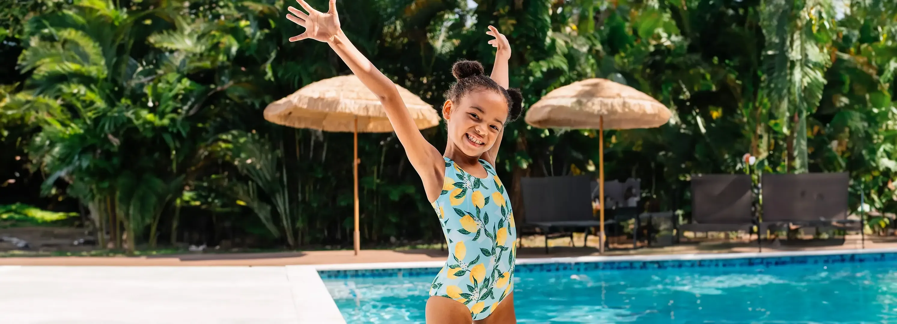 Girl wearing a blue one-piece lemon print bathing suit.