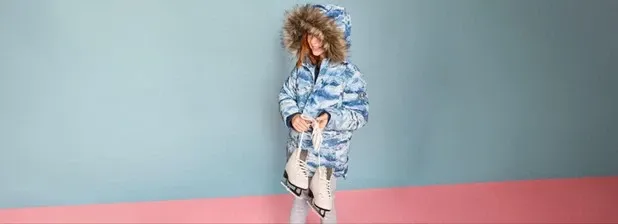 Girl wearing a blue waterproof winter down parka with hood.