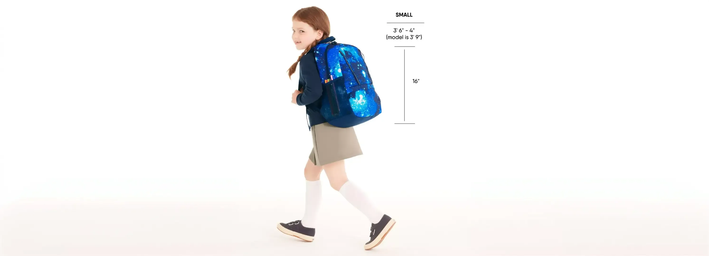Girl wearing a navy galaxy-print backpack and school uniform.