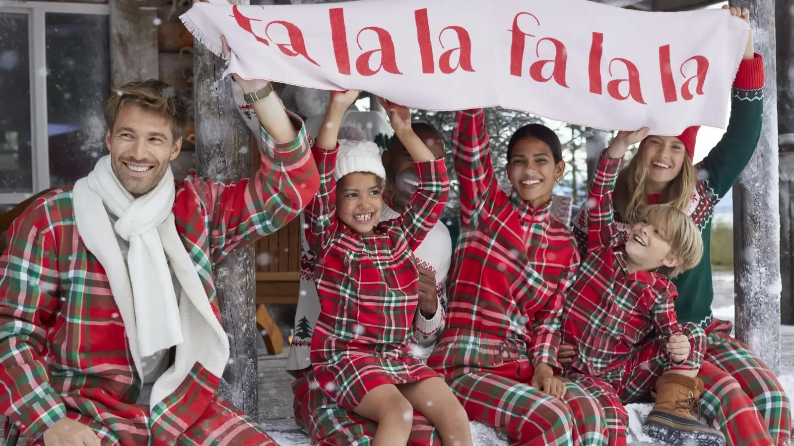 A group of friends celebrate the holidays in matching red plaid pajamas.