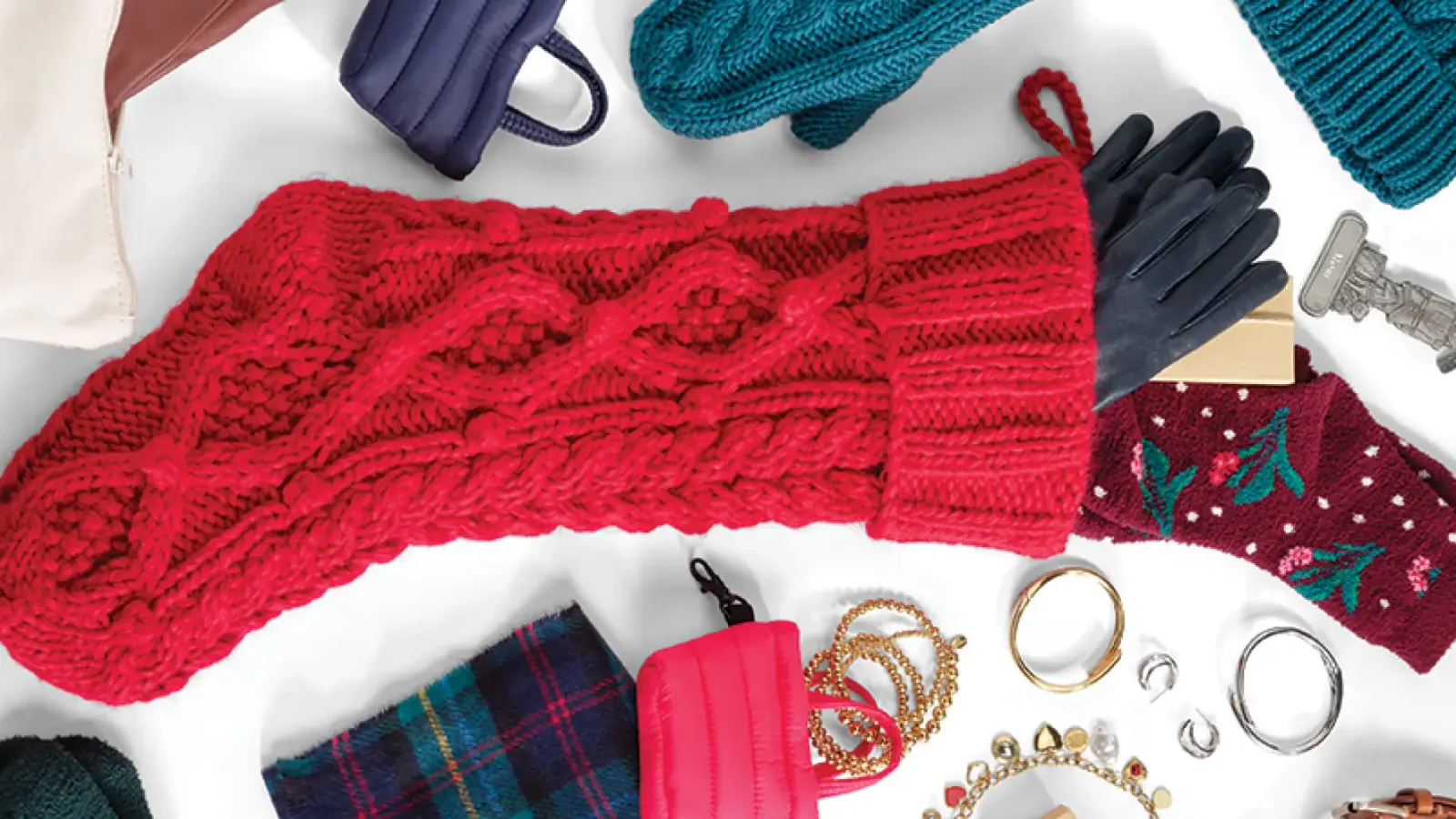 Festive holiday accessories including a red knit scarf, gloves, and jewelry.