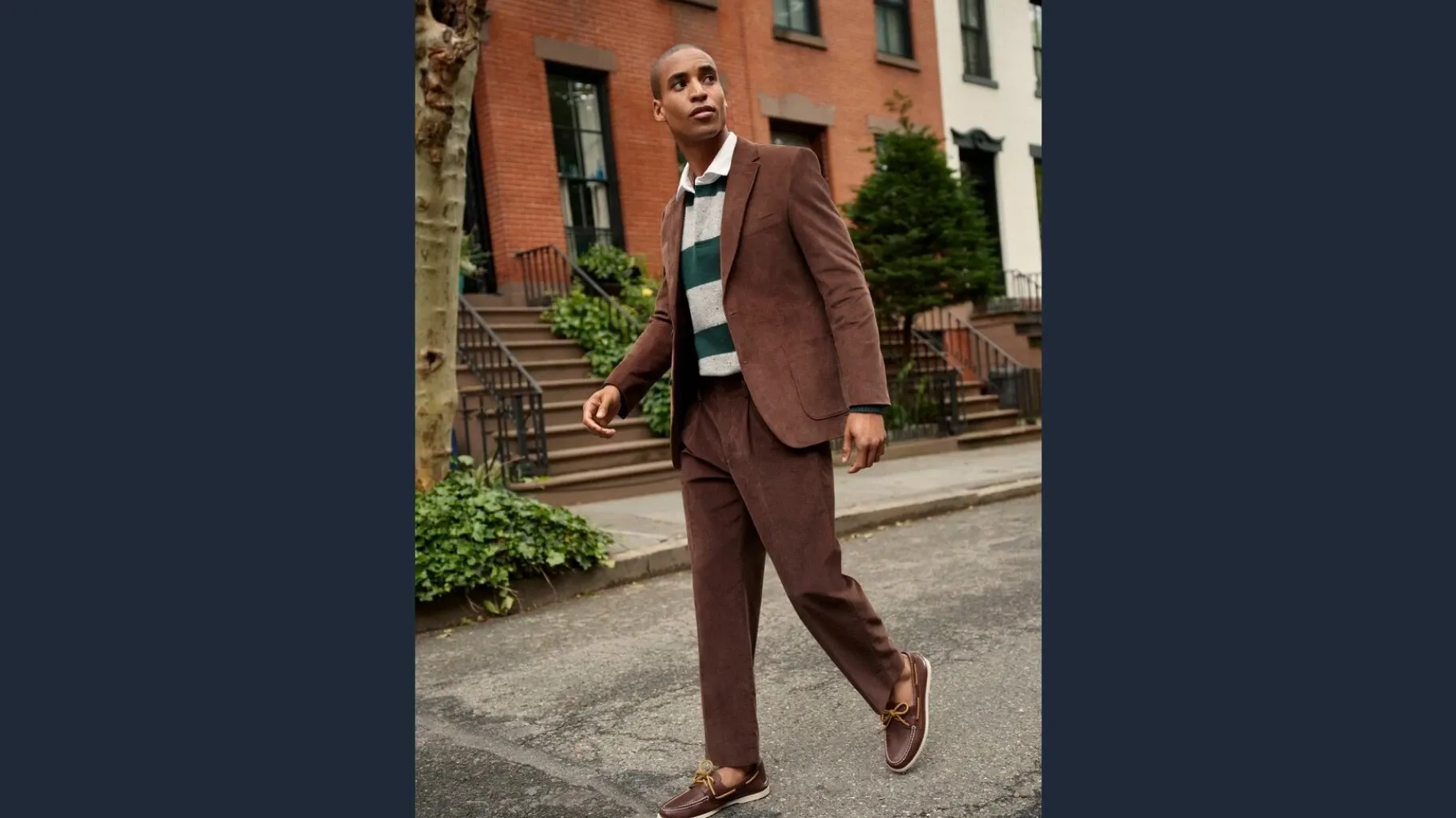 Man wearing a brown corduroy suit, green and gray rugby shirt and brown deck shoes.