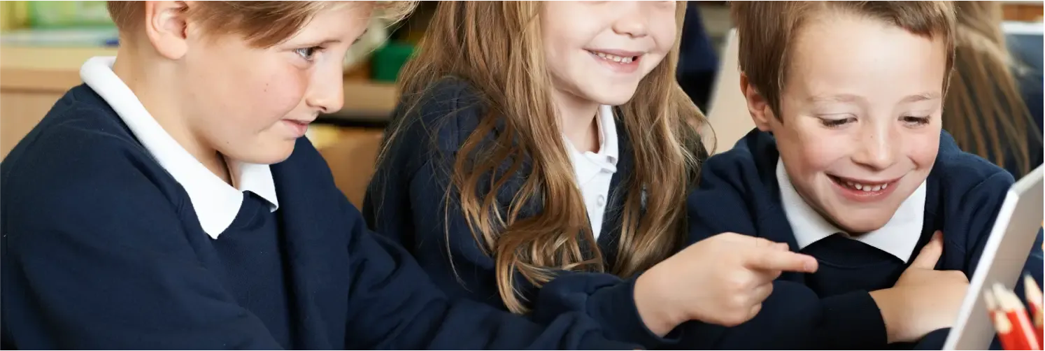 Three children wearing navy blue school uniforms with white collars.