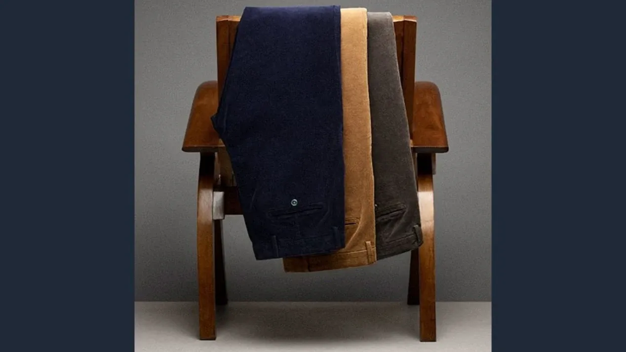 Three pairs of Lands' End women's corduroy pants arranged neatly over the back of a wooden chair.