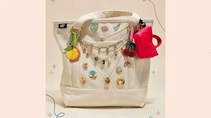 Canvas pocket tote decorated with charms, pins and keychains.