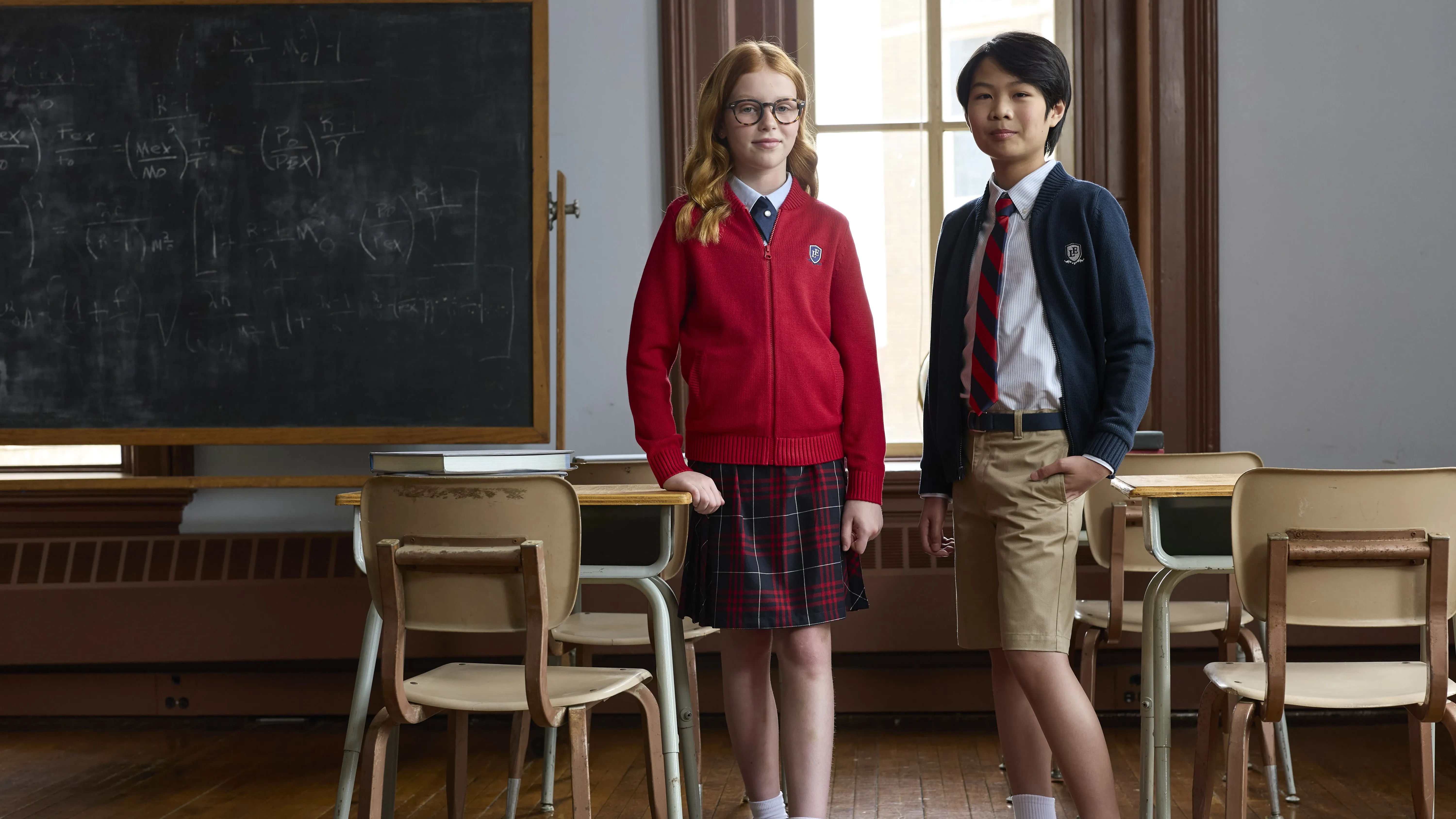 Two students wearing a Lands' End school uniforms in a classroom.