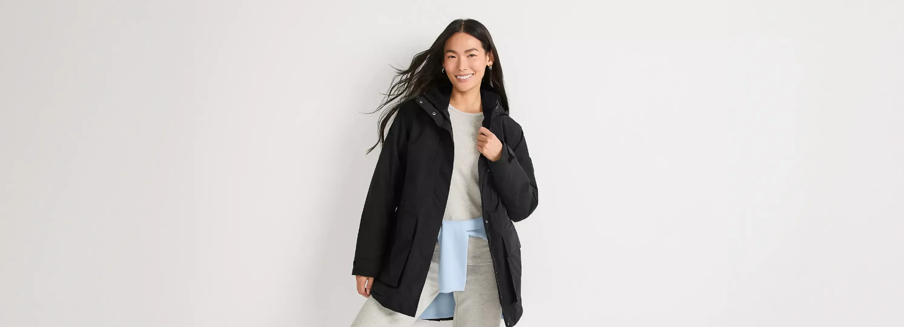 Woman wearing a black jacket over a grey outfit.
