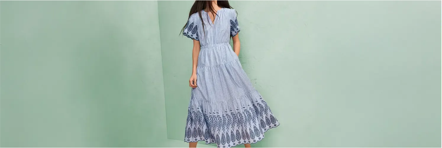 Woman wearing a blue and white embroidered maxi dress.