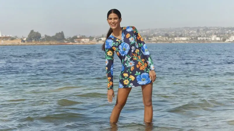 Woman wearing a blue floral UPF 50 swim dress.