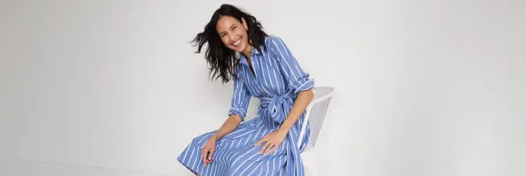 Woman wearing a blue and white striped shirt dress.