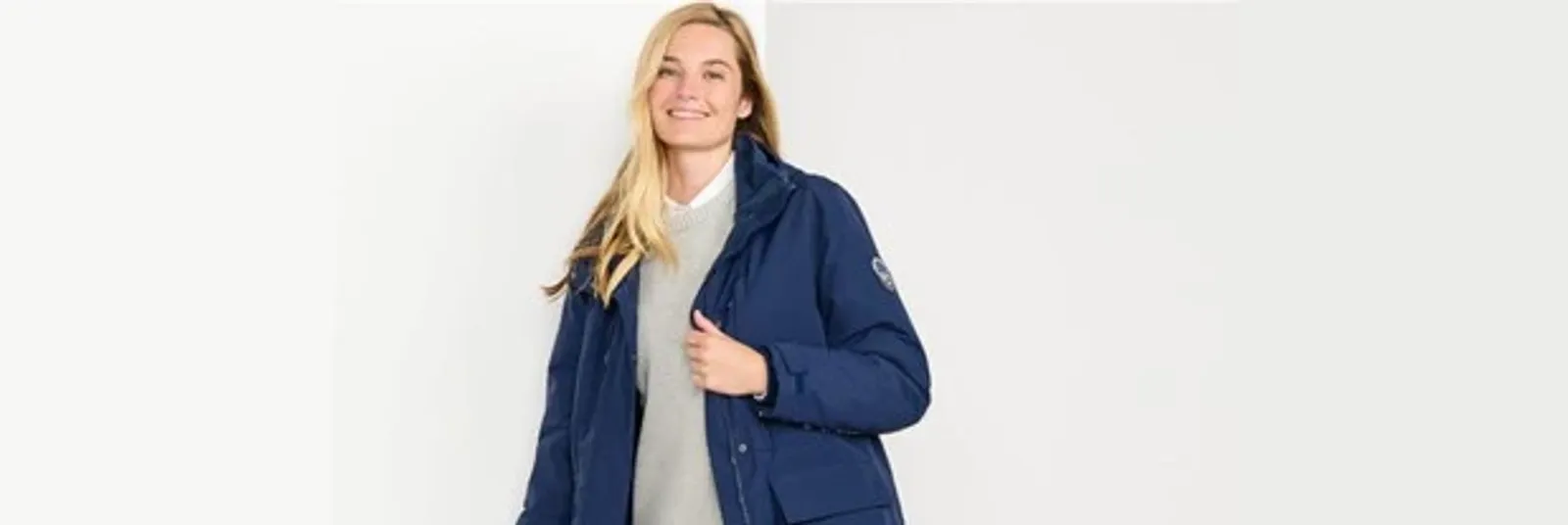 Woman wearing a navy blue, waterproof Squall parka.