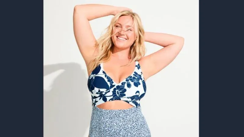 Woman wearing plus size white and blue floral bikini top.