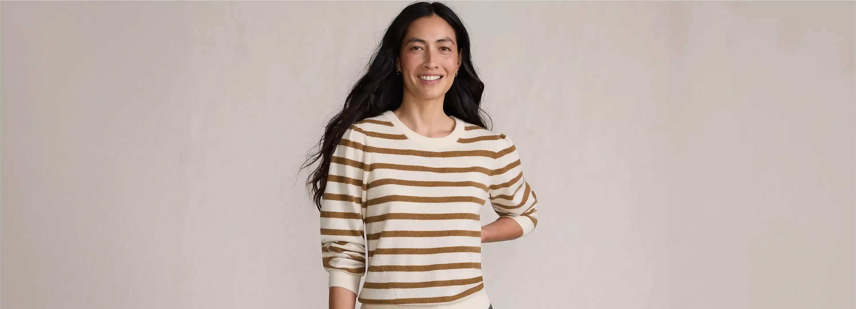 Woman wearing a brown and white striped sweater.