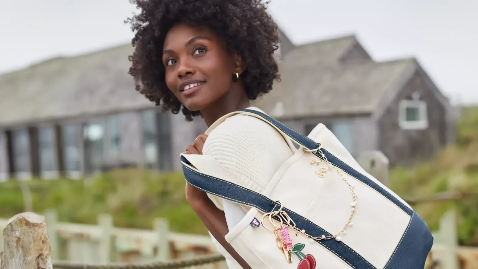 Woman wearing a white blouse carrying a Lands' End tote bag.