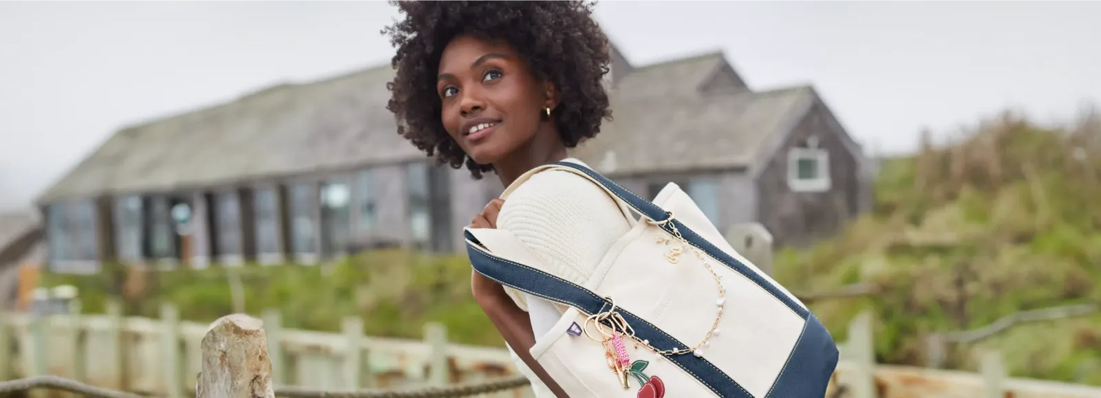Woman wearing a white blouse carrying a Lands' End tote bag.