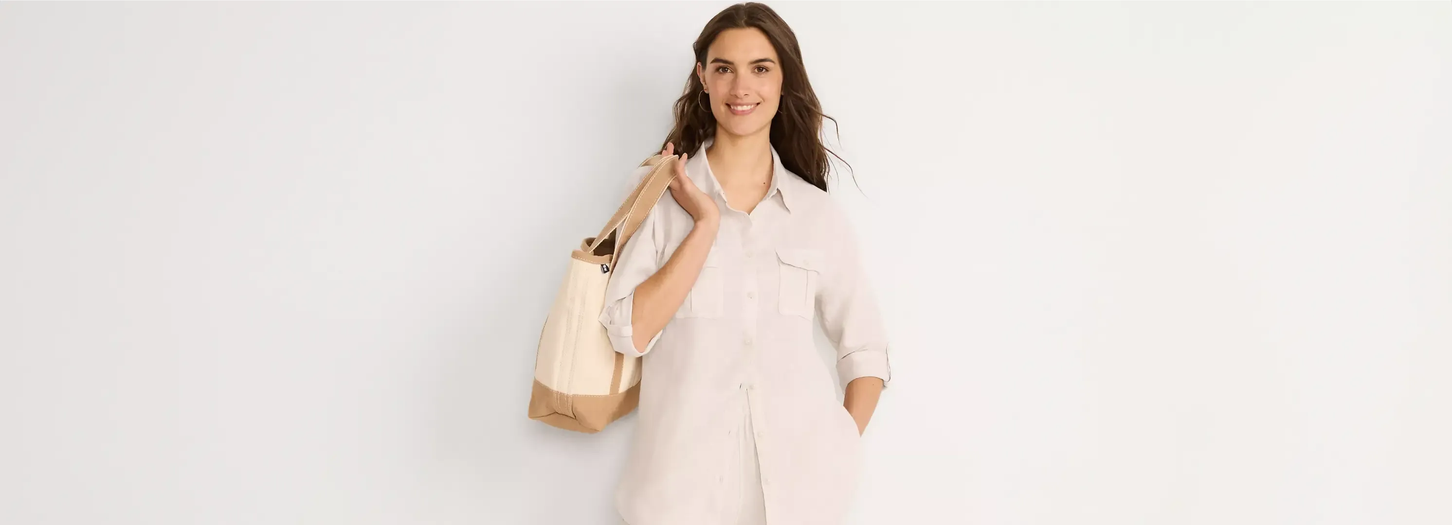Woman wearing White Linen Button-up Shirt carrying a Tote Bag.