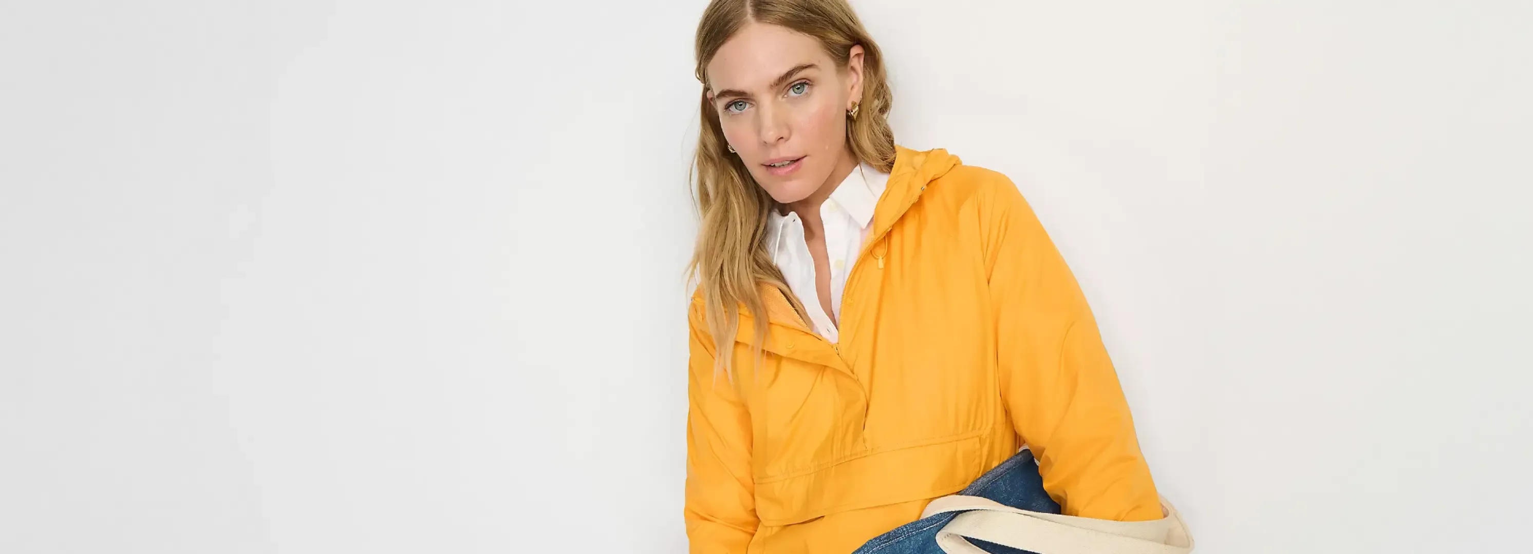 Woman wearing a yellow jacket over a white shirt.