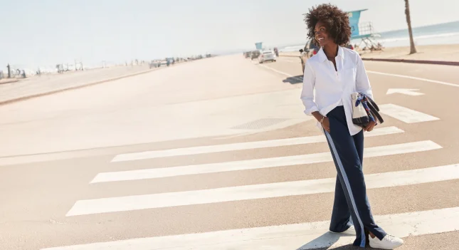 A woman walking along a crosswalk.
