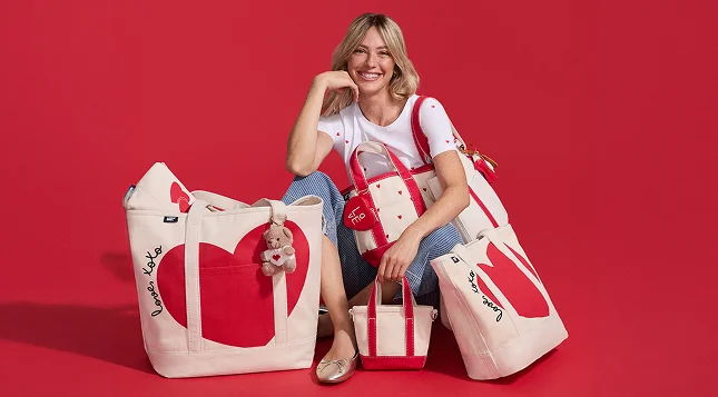 Woman wearing a tee and jeans and holding canvas totes