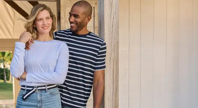 A woman wearing a long sleeve, solid color t-shirt and a man wearing a short sleeve, navy striped t-shirt.
