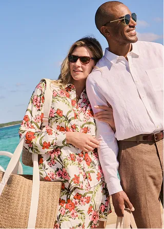 A couple on the beach wearing linen clothing.