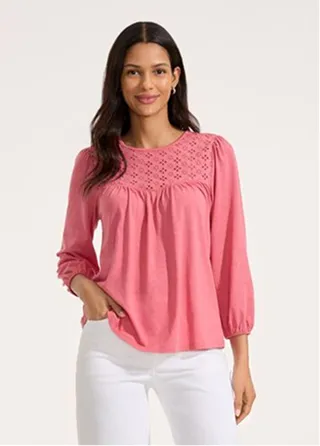 A woman wearing a pink blouse.