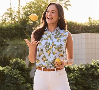 A woman wearing a patterned top juggles lemons.