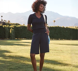 A woman wearing a dark v-neck top with matching colored shorts.