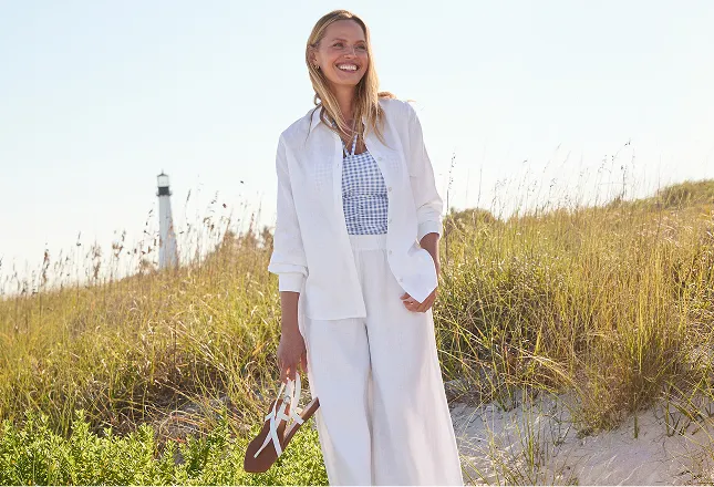 A woman wearing white linen top and pants.