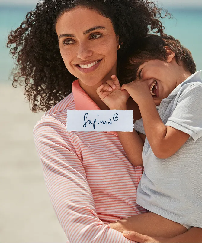 Torn paper that is labeled: Supima&reg;. A woman wearing a white and pink striped shirt holding a child.