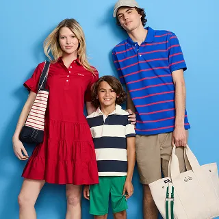 A woman wearing a red dress, a man wearing a blue and red striped polo, and a kid wearing a white nad navy striped polo.
