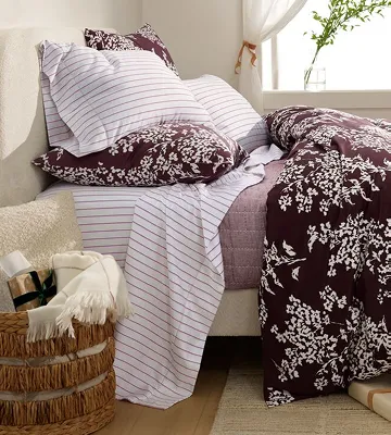 A bed with a white and black pattern comforter.