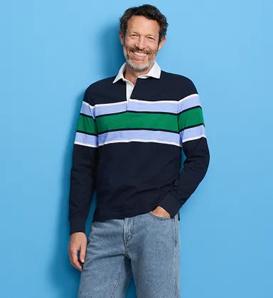 A man wearing a long sleeve navy top with white and green stripes.