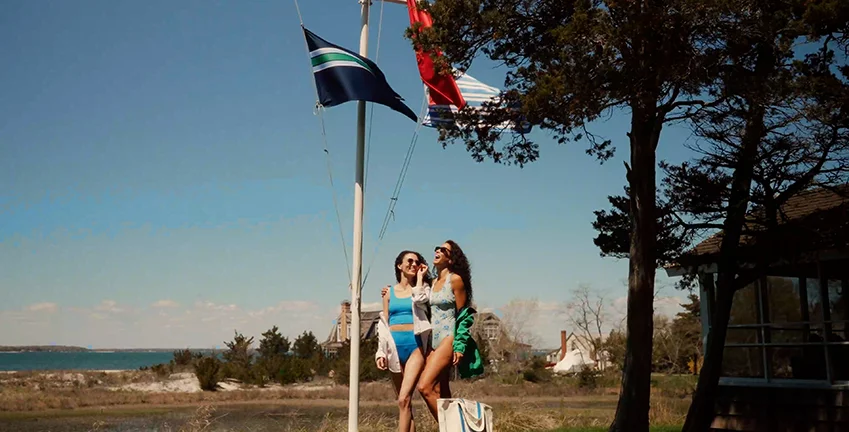 Two people wearing swimwear at a lake.