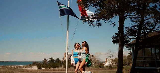 Two people wearing swimwear at a lake.