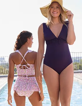 Two women wearing swimsuits in shades of pink and purple.