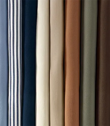 A folded stack of chino pants in different colors.
