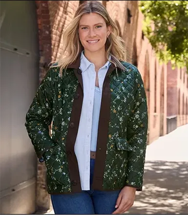A woman wearing a green patter n barn jacket.
