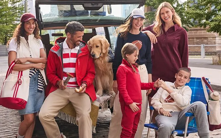 Several people and a golden retreiver tailgating for a sporting event.