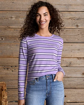 A woman wearing a purple and white striped Supima long sleeve top.
