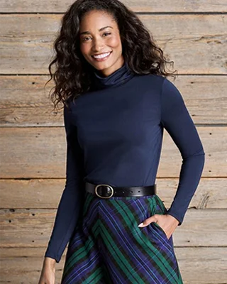 A woman wearing a navy turtleneck.