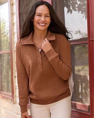 A woman wearing a brown waffle knit top.