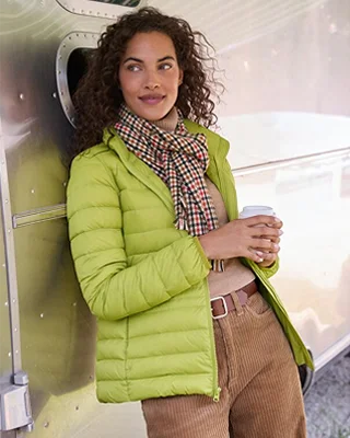 A woman wearing a green Wanderweight jacket.