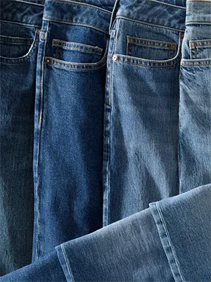 Four different shades of denim pants laid next to one another.