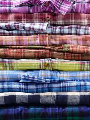 A stack of flannel shirts in different colors and patterns.